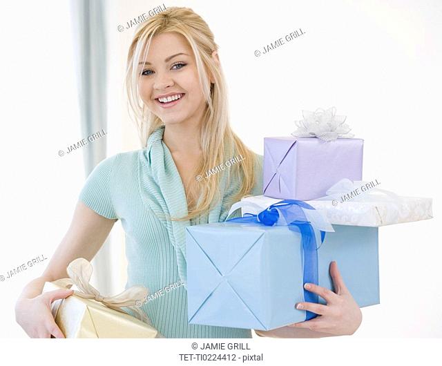 Woman holding stack of gifts