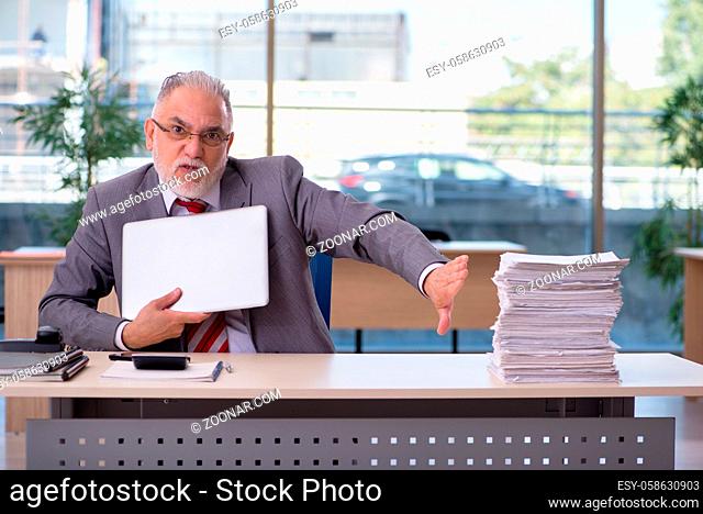 Aged male employee working in the office
