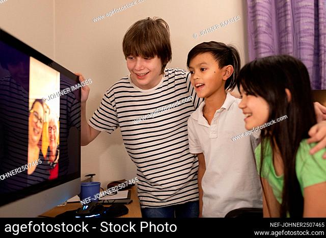 Children talking via vide chat with grandmother