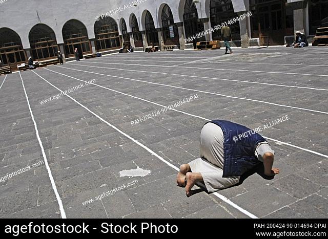 24 April 2020, Yemen, Sanaa: An elderly Yemeni man prays on the first day of the holy fasting month of Ramadan, at the grand Mosque in the old city of Sanaa