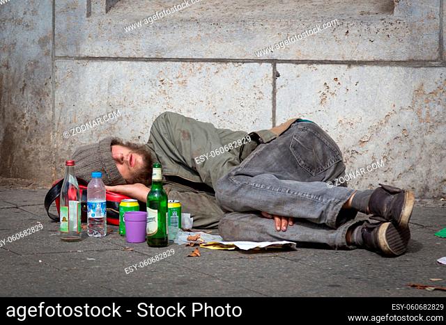 Berlin, Germany - Sept 18: Homeless young alcohol addict lying drunk on street sidewalk on 18th of September , 2016 in Berlin, Germany