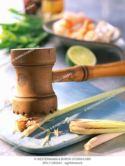 Lemongrass being crushed with a kitchen hammer
