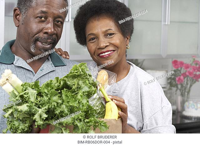 Middle-aged African American couple with groceries