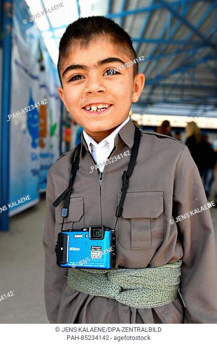 Nine-year-old Murat stands with a camera in a refugee camp in Aqrah, Iraq, 19 October 2016. Murat has received a small camera from UNICEF he uses to photograph...