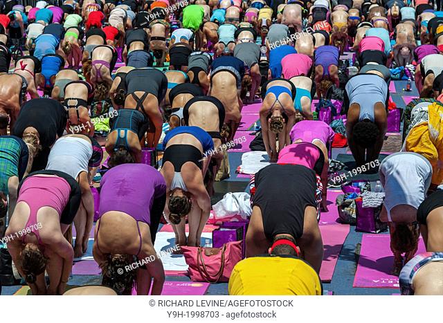 Thousands of yoga practitioners pack Times Square in New York to participate in a mid-day Bikram Yoga class on the first day of summer