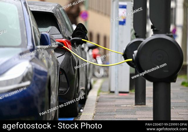PRODUCTION - 23 March 2023, Hesse, Frankfurt/Main: E-cars are parked in the city center at novel e-charging stations from the Munich-based charging operator...