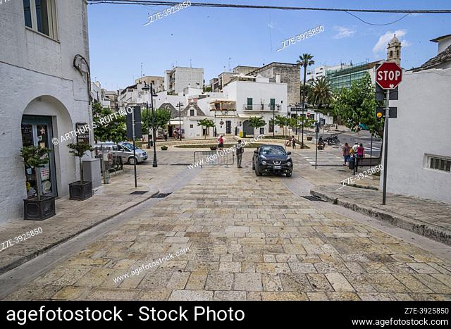 Town of Alberobello. Street with pavers leads to Rioni Monti District with trulli architecture. Metropolitan City of Bari, Puglia (Apulia), Italy