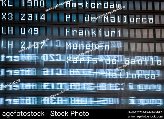 14 July 2022, Lower Saxony, Hanover: Information boards on departures and gate information are reflected in a pane at Hannover Airport in Terminal A