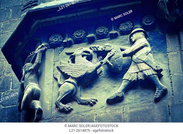 Medieval relief, a soldier fighting with a monster. Sant Iu Gate, Cathedral of the Holy Cross and Saint Eulalia, Barcelona, Catalonia, Spain