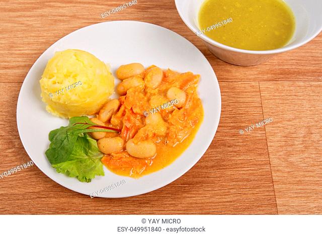 Beans with carrots and potatoes on a wooden table