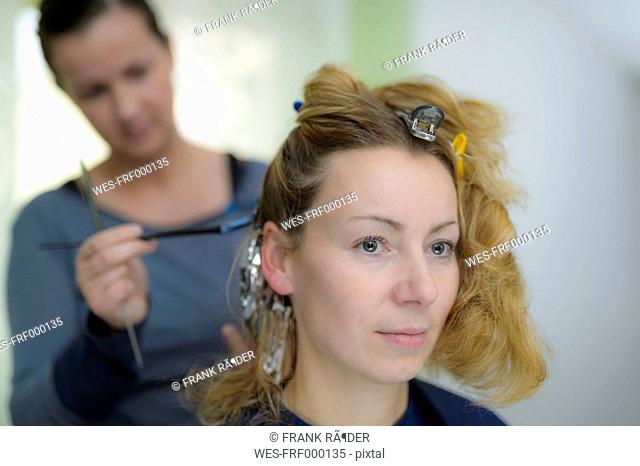 Portrait of woman getting highlights at hairdresser