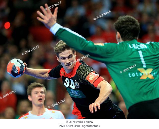 Germany's Rune Damke(C) in action against Denmark's Niklas Landin Jacobsen (R) during the 2016 Men's European Championship handball group 2 match between...