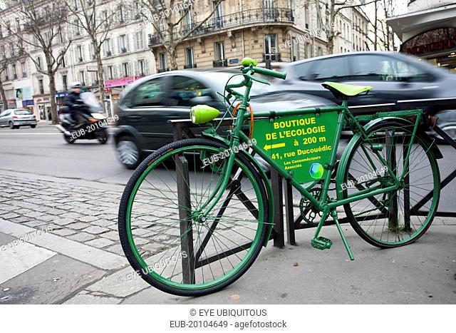 Denfert Rochereau Green bicycle padlocked against railings advertising Boutique de LEcologie