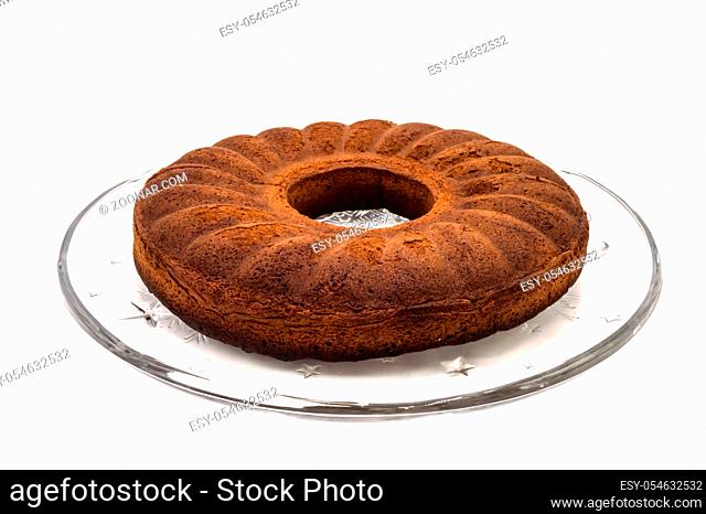 Circular marbled cake laying on a glass tray on a white background