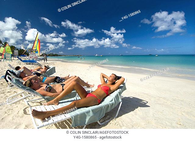Antigua, Dickenson Beach, young ladies sunbathing