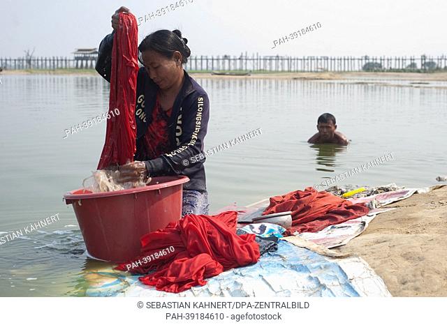 Myanmar A woman is cleaning monk robes on the shores of the Taungthaman Lake in front of the U Bein Bridge in Amarapura, Myanmar, on 02.04.2013