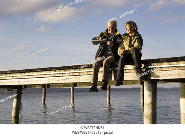 Senior couple sitting on jetty