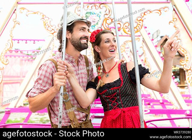 Woman and man enjoying a swing on the Oktoberfest or Bavarian fair
