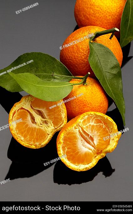 vivid orange tangerine on black reflective surface