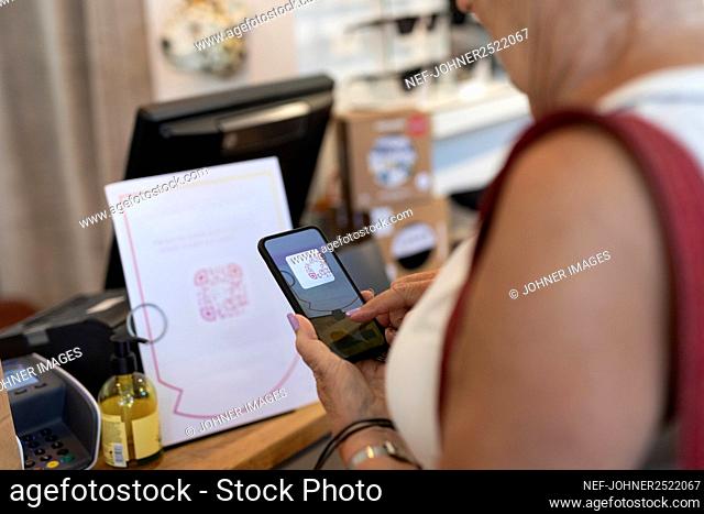 Woman in shop using cell phone
