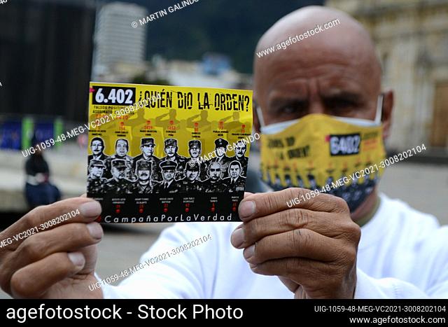 A man holds up a poster that says Who gave the order? in rejection of the more than 6, 402 murders of innocent civilians committed by the Colombian army during...
