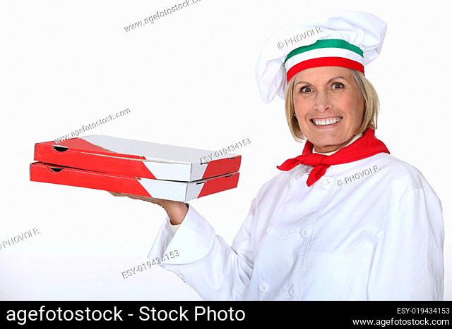 mature female pizza cook holding pizza packets