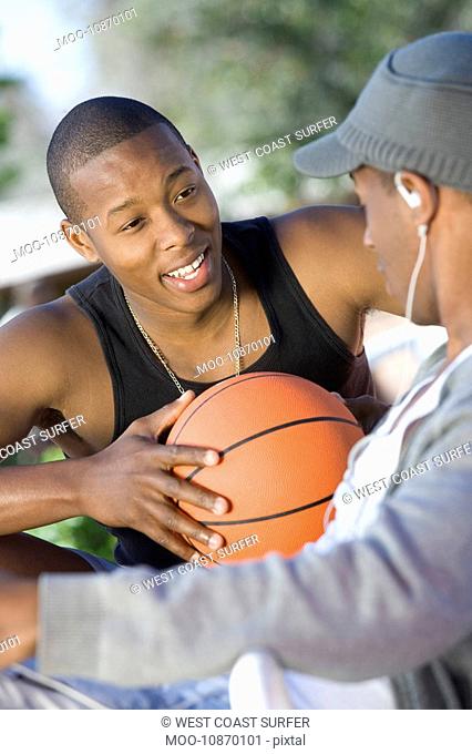 Two Young Men with Basketball Talking