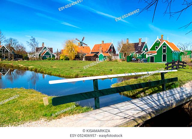 Zaanse Schans, Holland traditional village houses and bridge, windmill against blue sky