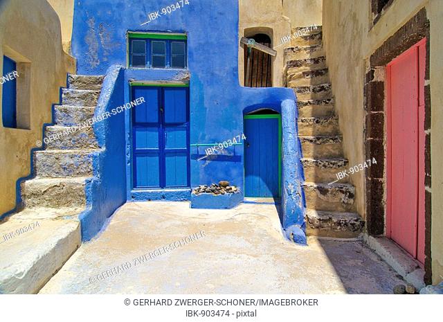 Yellow house with an inner courtyard with stairs and coloured doors in a typical Cycladic architectural style, Oia, Ia, Santorini, Cyclades, Greece, Europe