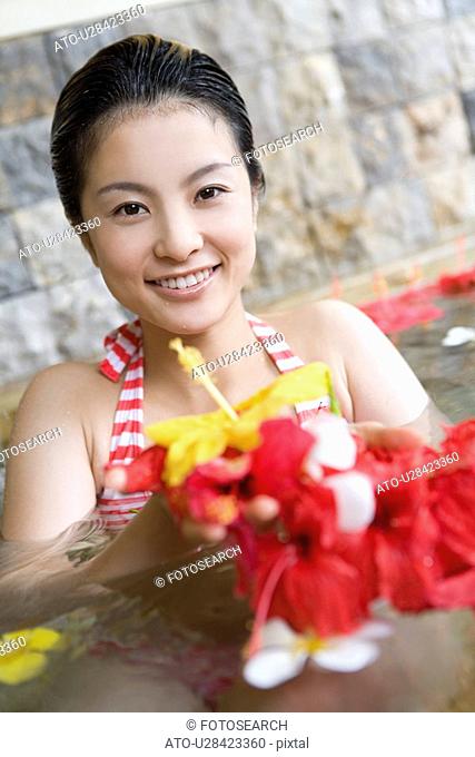 Young woman holding out flowers, Saipan
