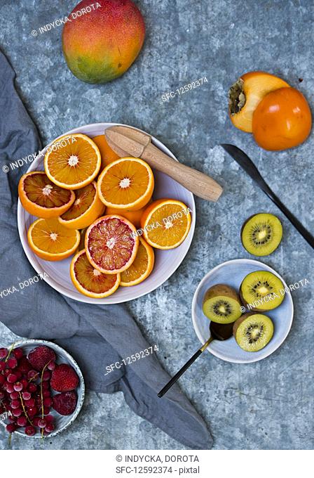 Fresh fruits: blood oranges, mango, persimmons, kiwis and iced berries