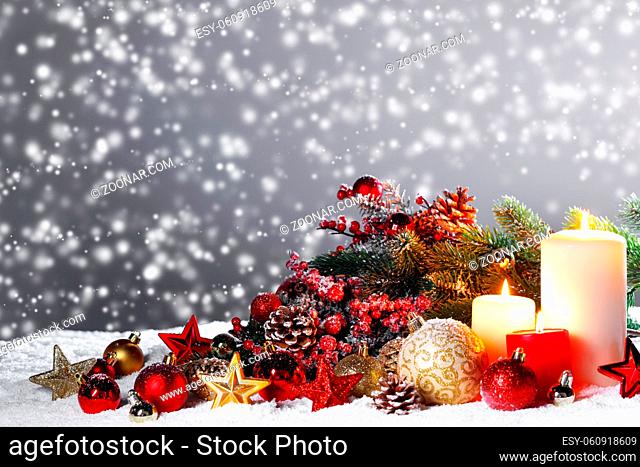 Christmas composition of colorful ornaments balls stars candles and fir tree branches on snow
