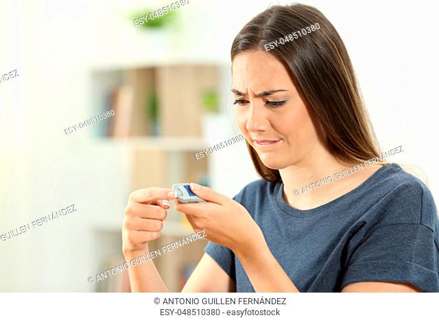 Diabetic girl checking blood sugar level with a glucometer