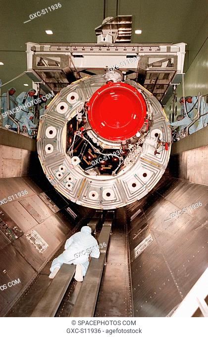 10/22/1998 --- In the Space Station Processing Facility, workers at the side and on the floor of the payload canister guide the Unity connecting module into...