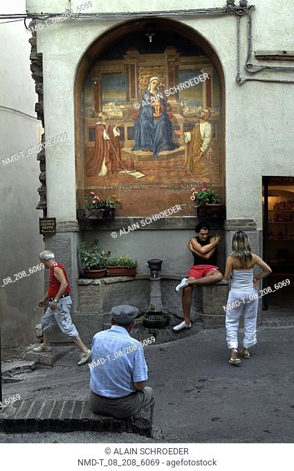 Four people in front of a building, Spello, Umbria, Italy