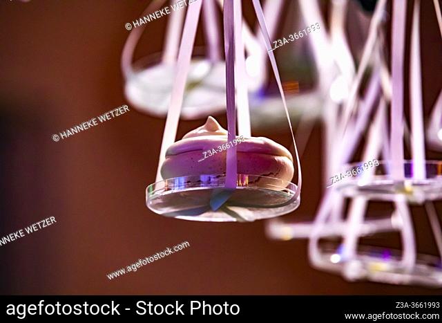 Merengues hanging from a lighted design cloud construction as a decor for the presentation of desserts, Strijp-S, Eindhoven, The Netherlands, Europe