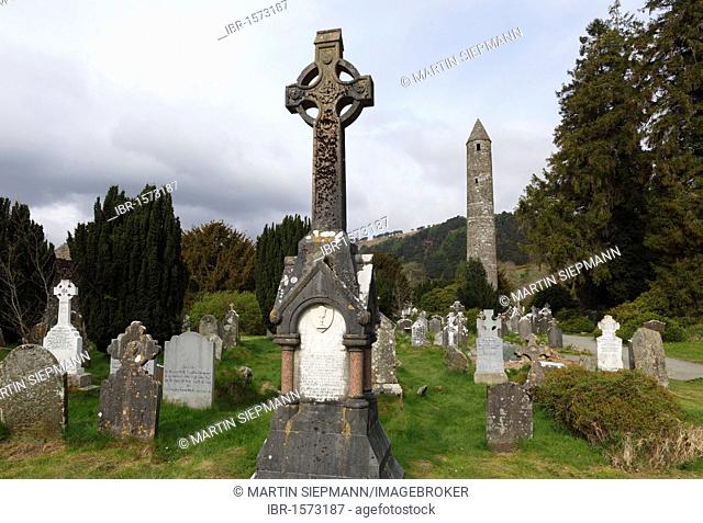 High cross, round tower and cemetery site at Glendalough monastery, Wicklow Mountains, County Wicklow, Republic of Ireland, British Isles, Europe