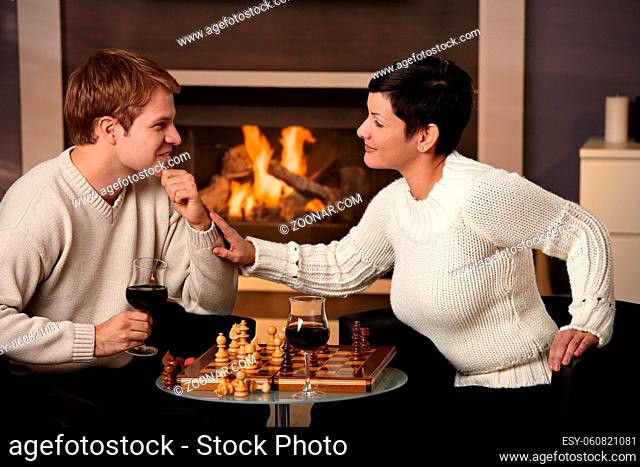 Young couple playing chess at home on a cold winter day