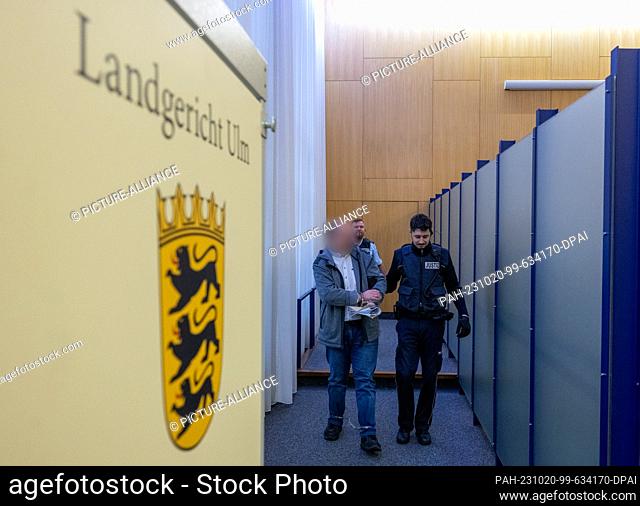 20 October 2023, Baden-Württemberg, Ulm: A judicial constable (r) leads a man into the courtroom at the beginning of a trial for attempted quadruple murder