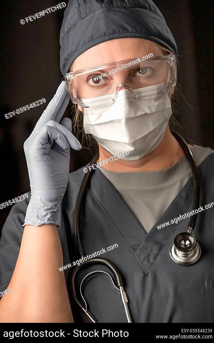 Female Doctor or Nurse Wearing Scrubs, Protective Face Mask and Goggles