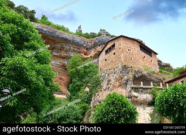 Stone house over a big rock close of a cliff at Orbaneja del Castillo, Burgos, Spain, Europe