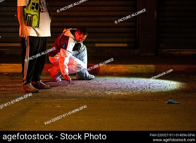 27 March 2022, Israel, Hadera: A member of the Zaka voluntary organization inspects the scene where two people were killed by gunmen in Hadera