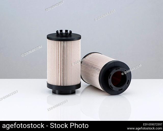 two automotive filter cylindrical shape on a white background with reflection