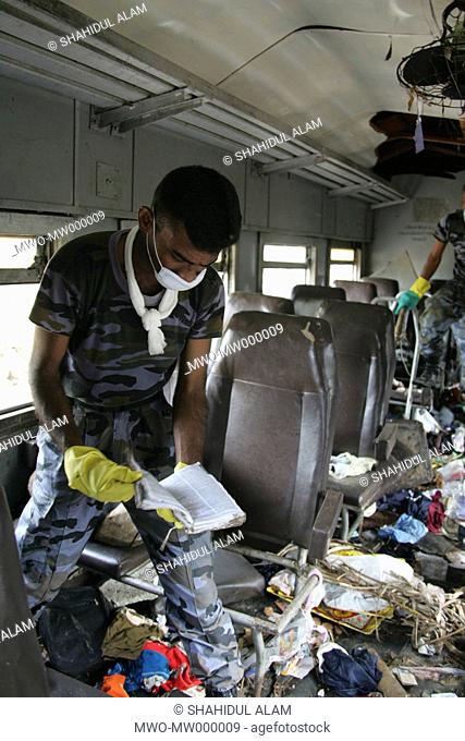 A soldier searches through the scattered belongings on a train for clues to identify the missing and the dead in Indian Ocean tsunami in 2004 Sri Lanka January...