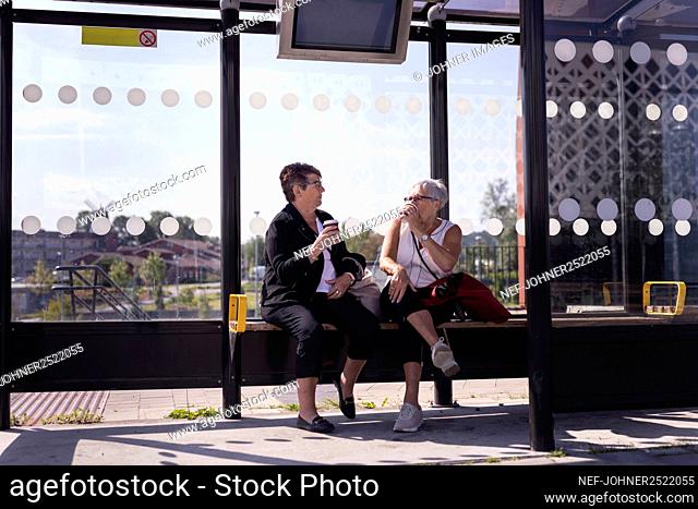 Senior female friends at bus stop