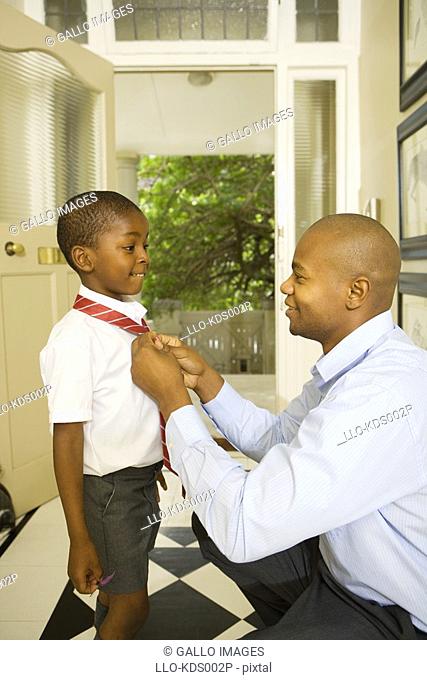 African Man Tying his Son's School Tie  Cape Town, Western Cape Province, South Africa