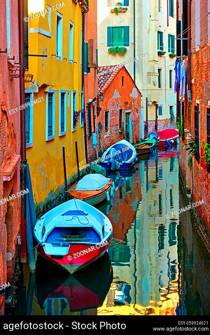 Perspective of venetian canal with moored boats, Venice, Italy