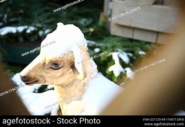 29 November 2023, Saxony, Leipzig: A figure of a sheep covered in snow stands at the Leipzig Christmas market. The market can be visited from 28.11