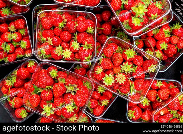 Baskets full of fresh delicious red healthy strawberries from a fruit market