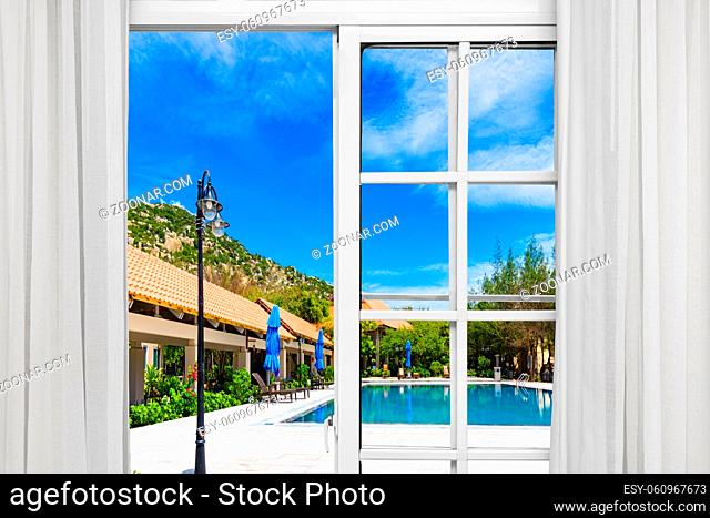 deck chairs under a canopy stand near the swimming pool window open